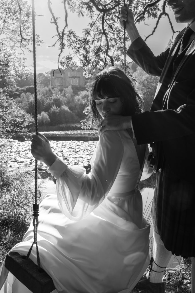 Bride on a swing with her husband at Auchen Castle in Scotland
