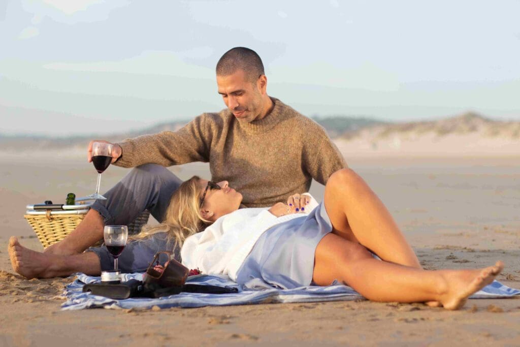 A couple lay on the beach in Ayrshire for their engagement photoshoot