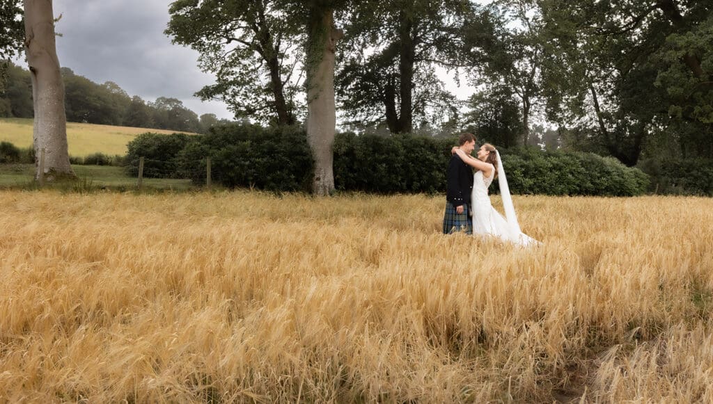 bride and groom embrace in a hug on the garden grounds at Enterkine country house.