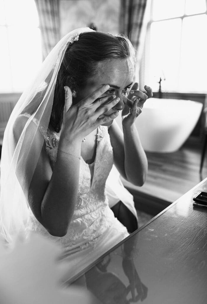the bride is overcome with emotion  looks at herself in the mirror once in her dress