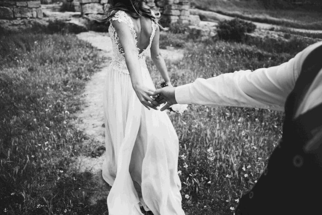 The bride leads her husband through the gardens of a castle in scotland
