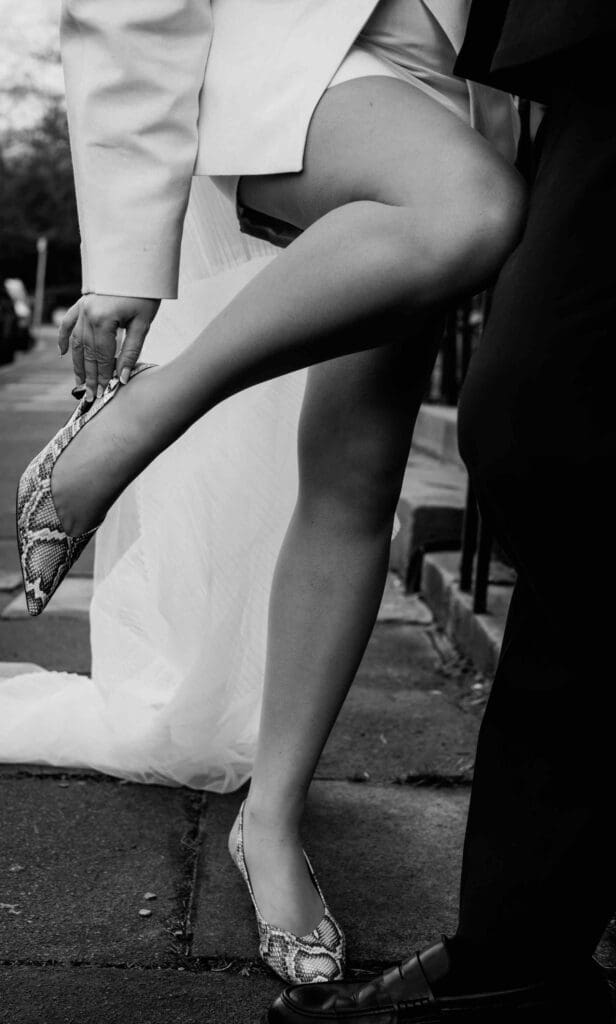 A bride adjusts her shoe in the west end of Edinburgh at a city centre wedding 