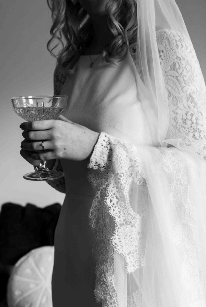 A bride sips champagne in her wedding dress before the ceremony