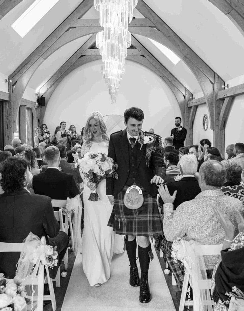 Guests cheer as the bride and groom depart the wedding venue in Glasgow